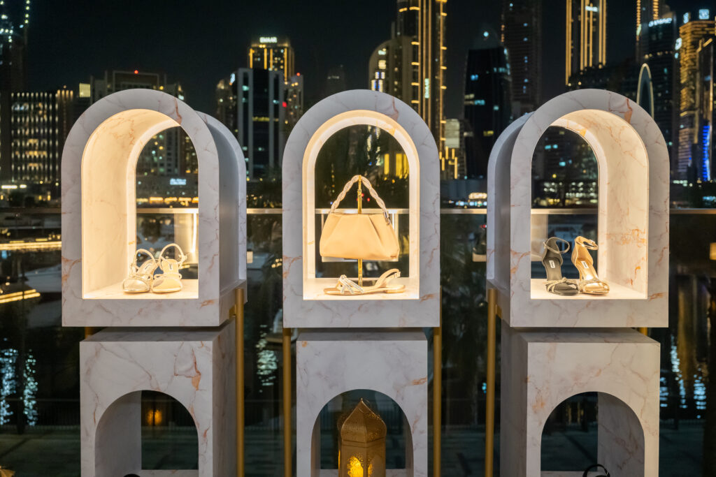 Dune London accessories displayed in illuminated arches at night